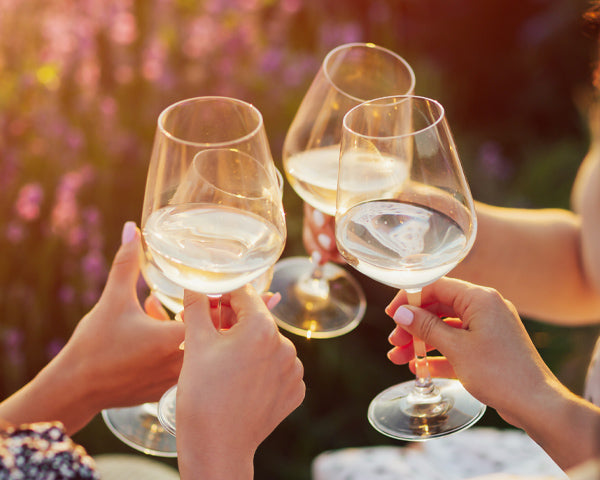 Brindisi con calici di vino bianco